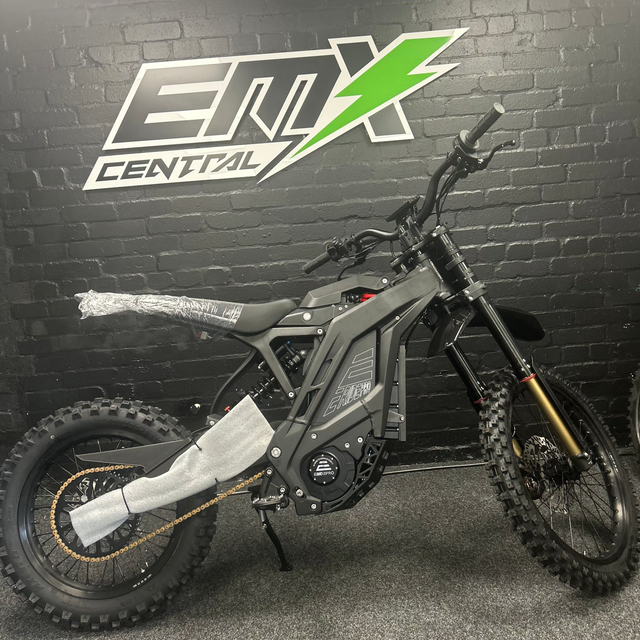 Electric bike in front of a black brick wall with 'EMX Central' logo.