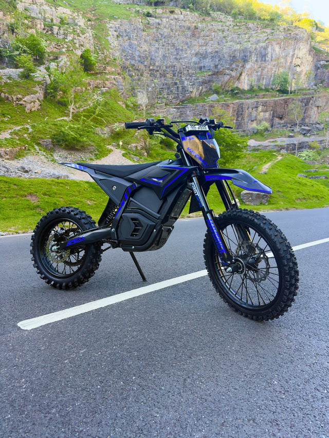 Blue electric bike on a road with a rocky landscape in the background