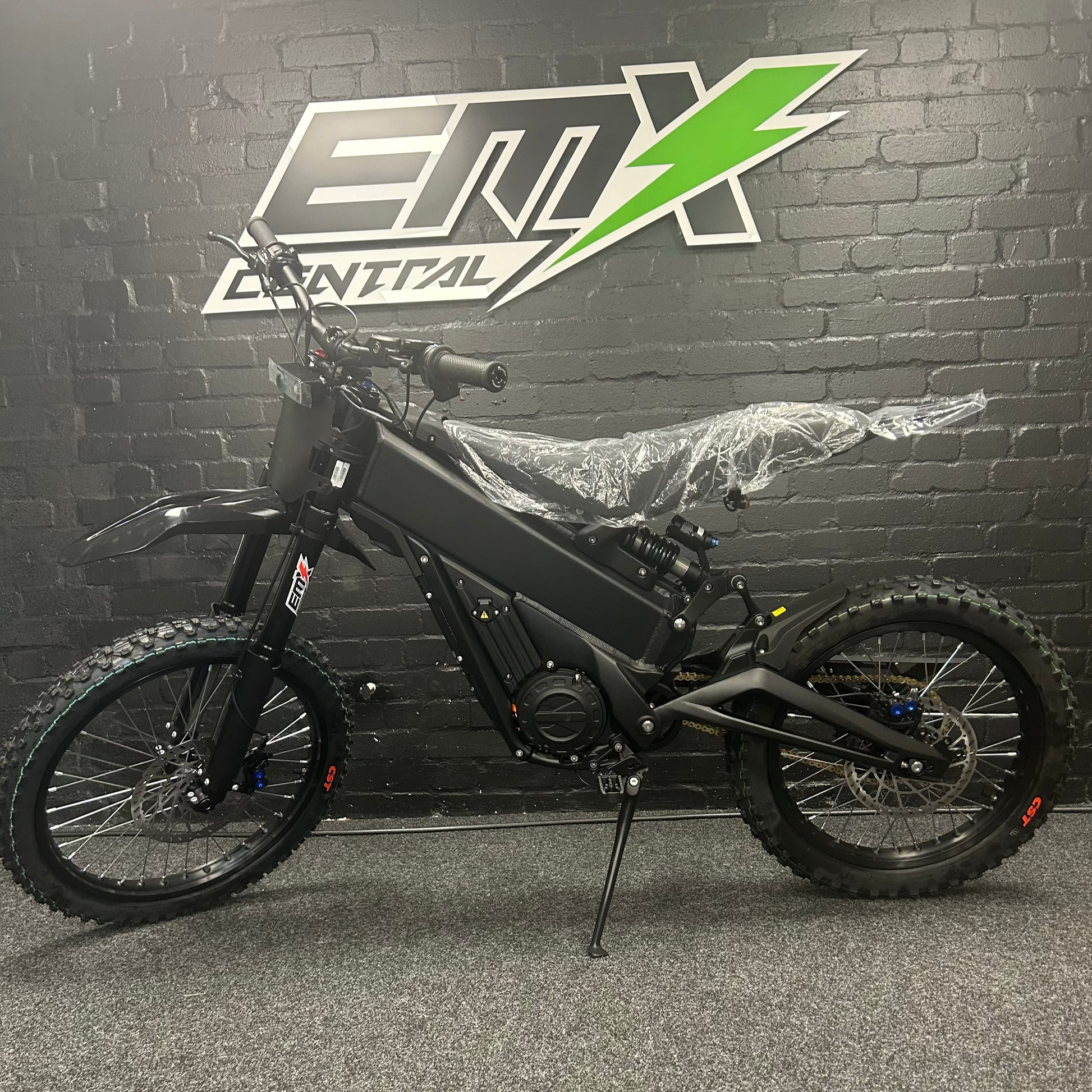 Black electric bike in front of a branded wall
