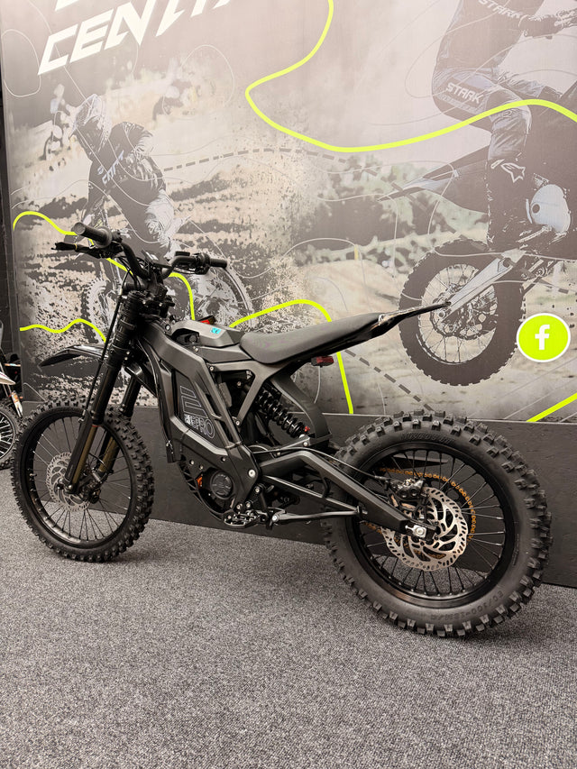 Black electric bike on a gray surface with a promotional banner in the background
