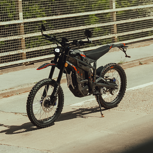 Electric bike on a paved road with a wire fence in the background