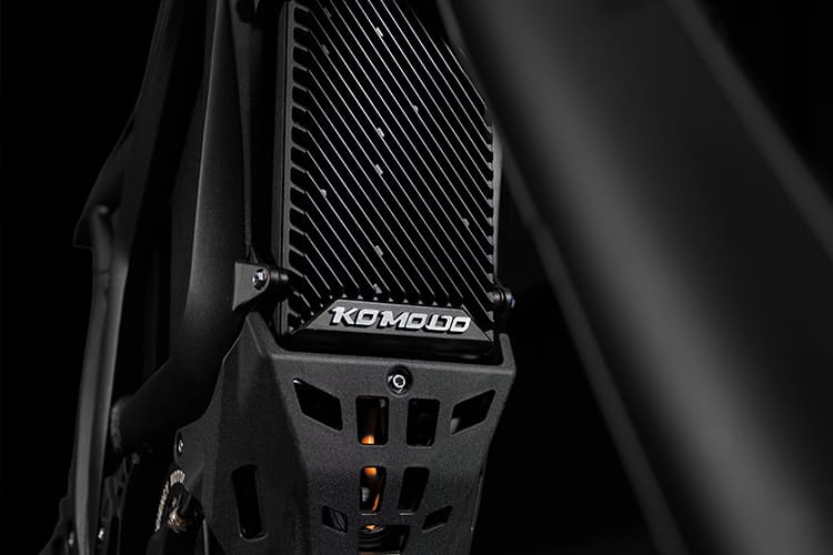 Close-up of a black metal frame with 'KOMODO' branding on a dark background