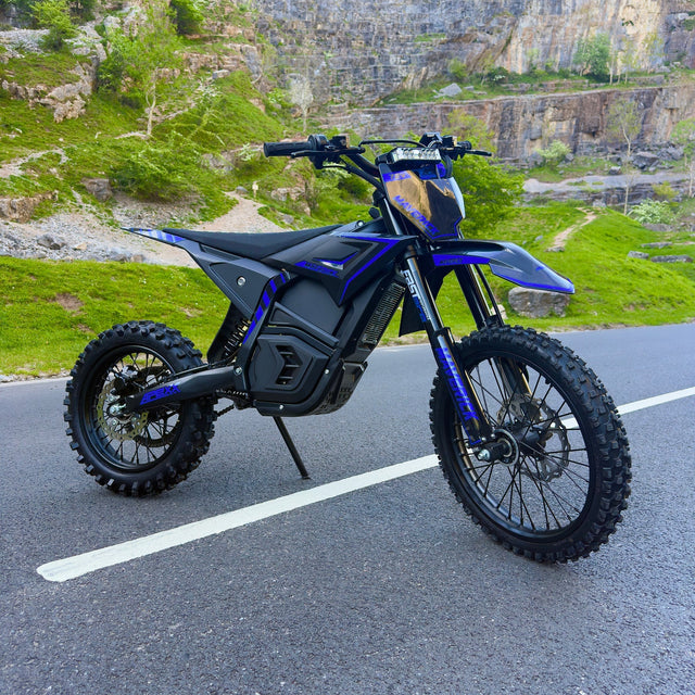 Blue electric bike on a road with a rocky landscape in the background